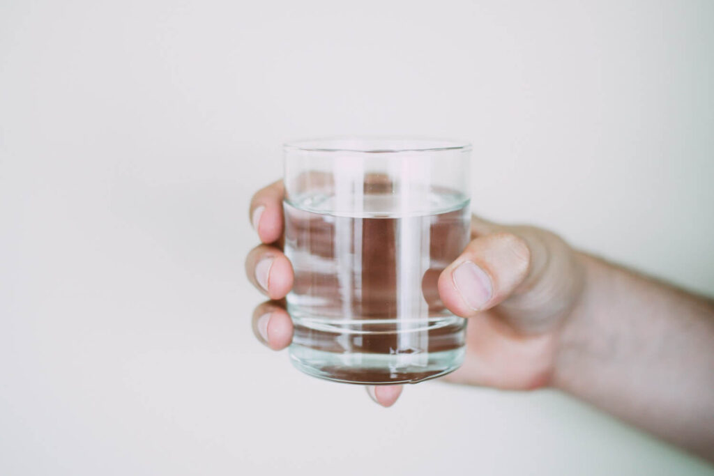 Glass of fresh water being held by a hand