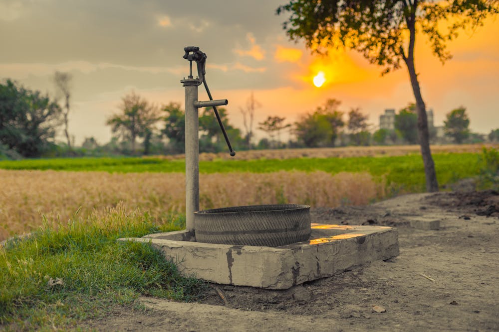 Hand water pump on the side of a field