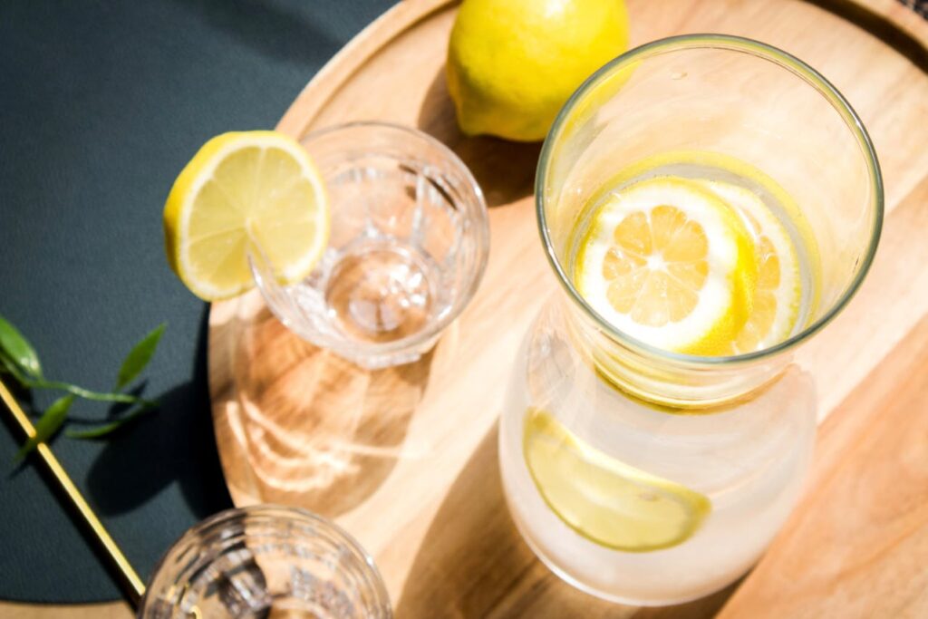 glasses with lemon on a round, wooden board